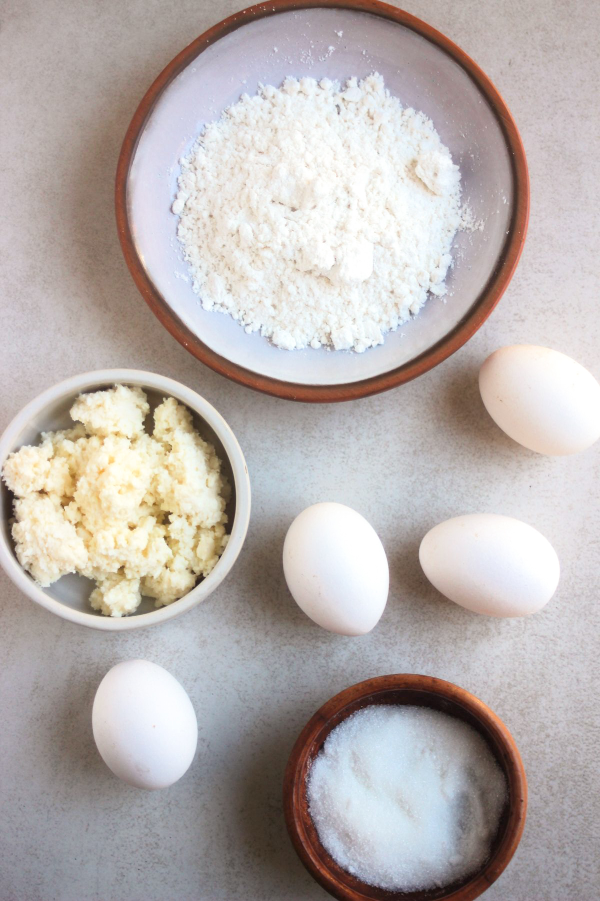 Top view of cottage cheese pancakes ingredients on a white surface.