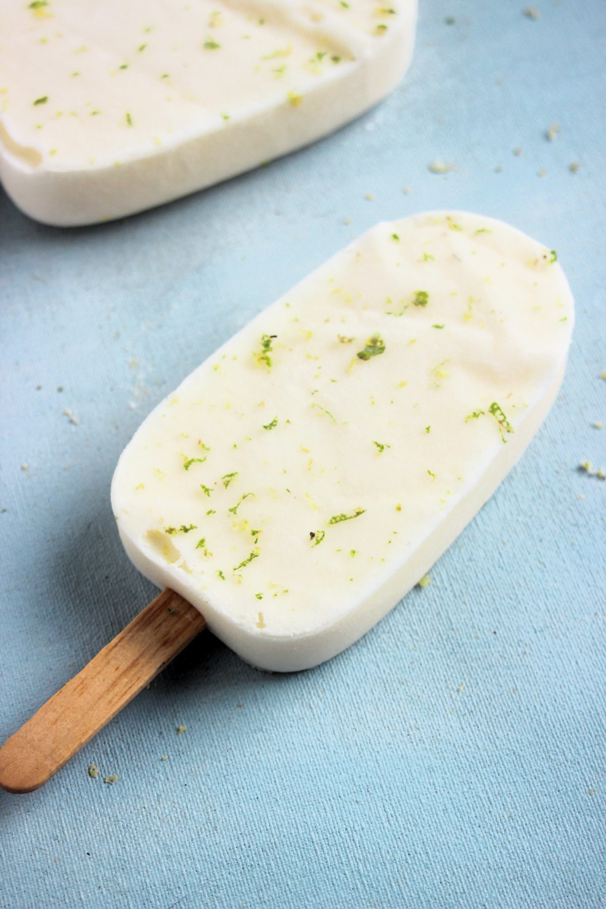 Lime popsicle on a light-blue surface.
