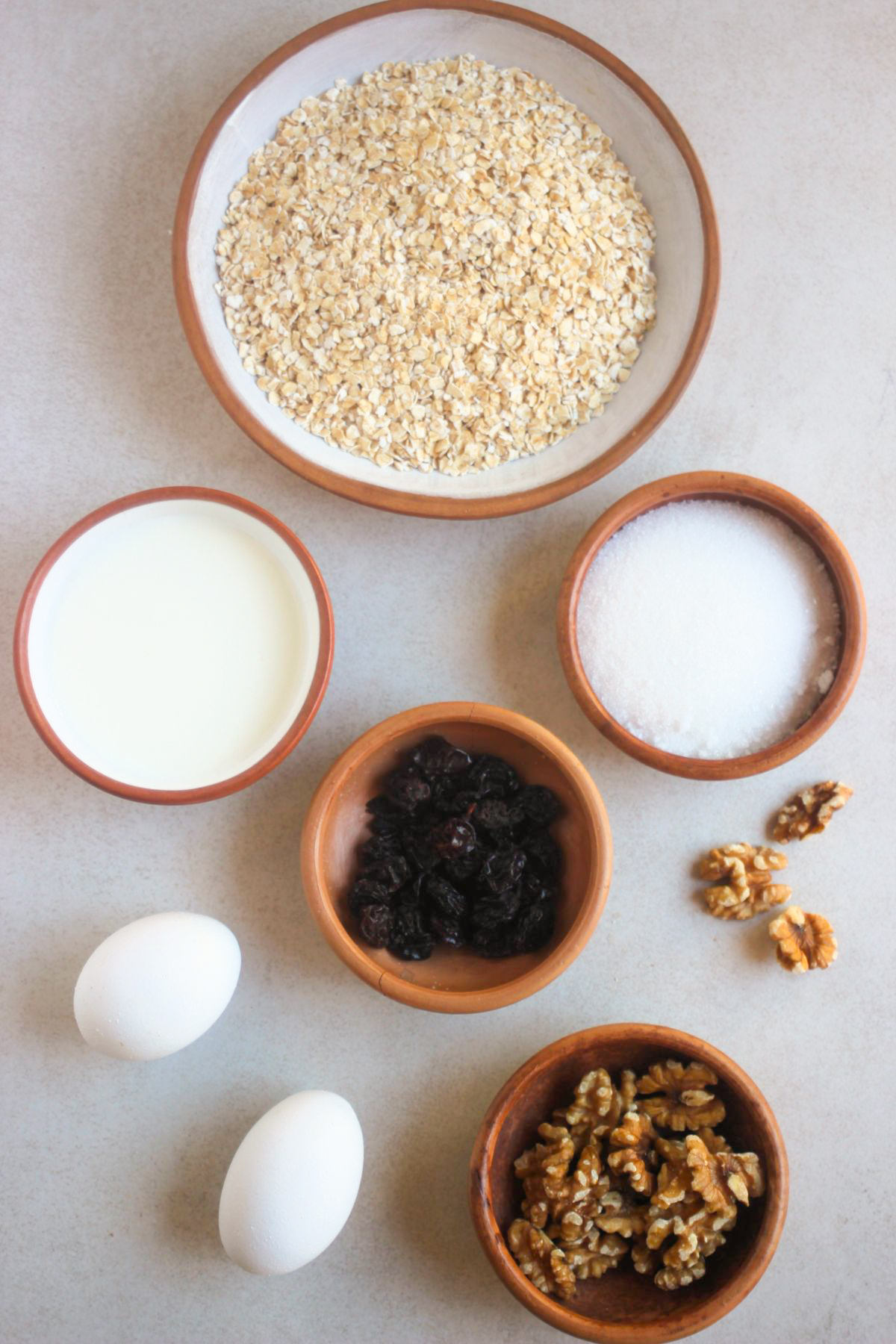 Top view of the ingredients for baked oatmeal bars on a white surface.