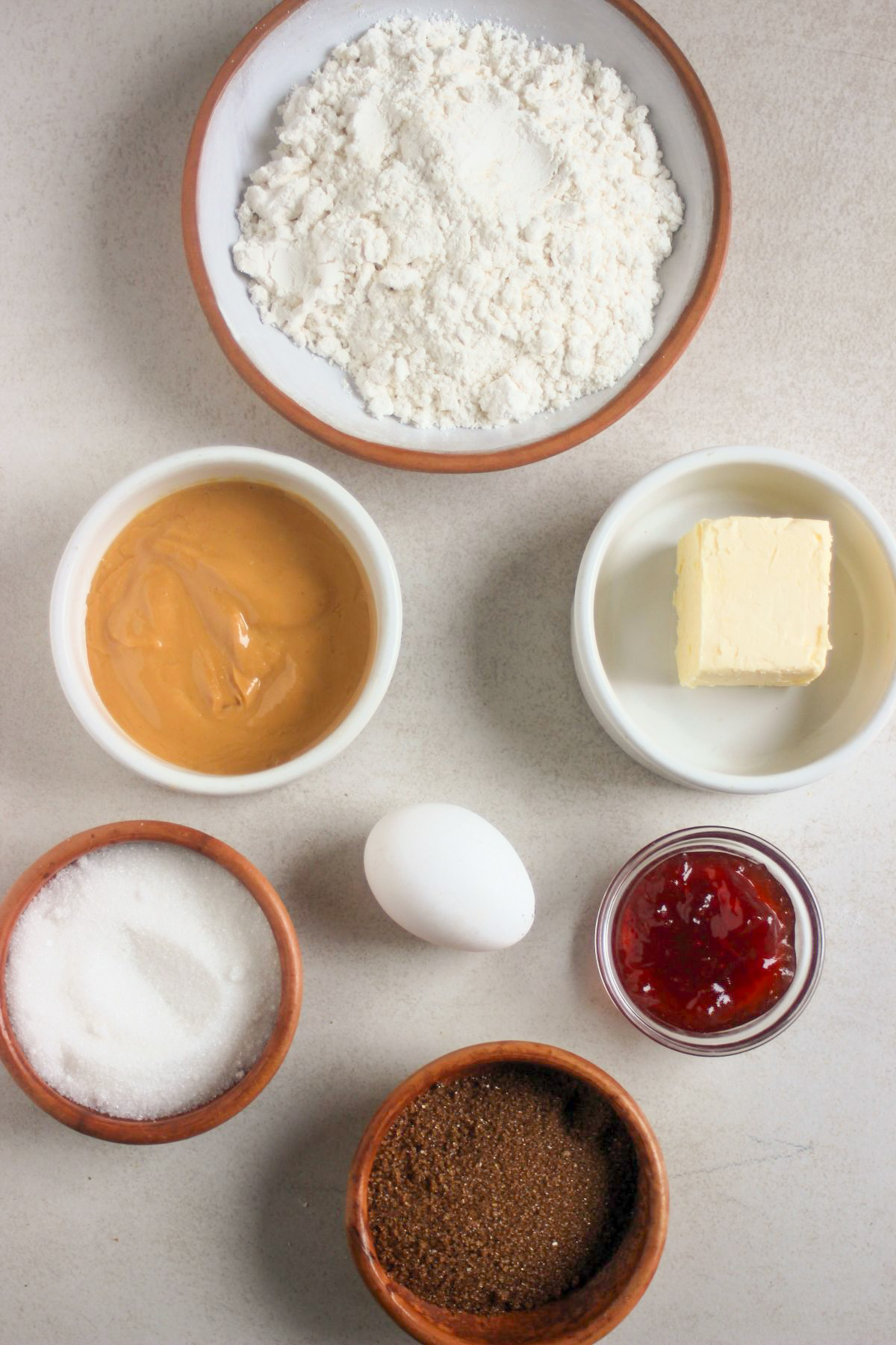 Top view of peanut butter thumbprint cookies ingredients on a white surface.