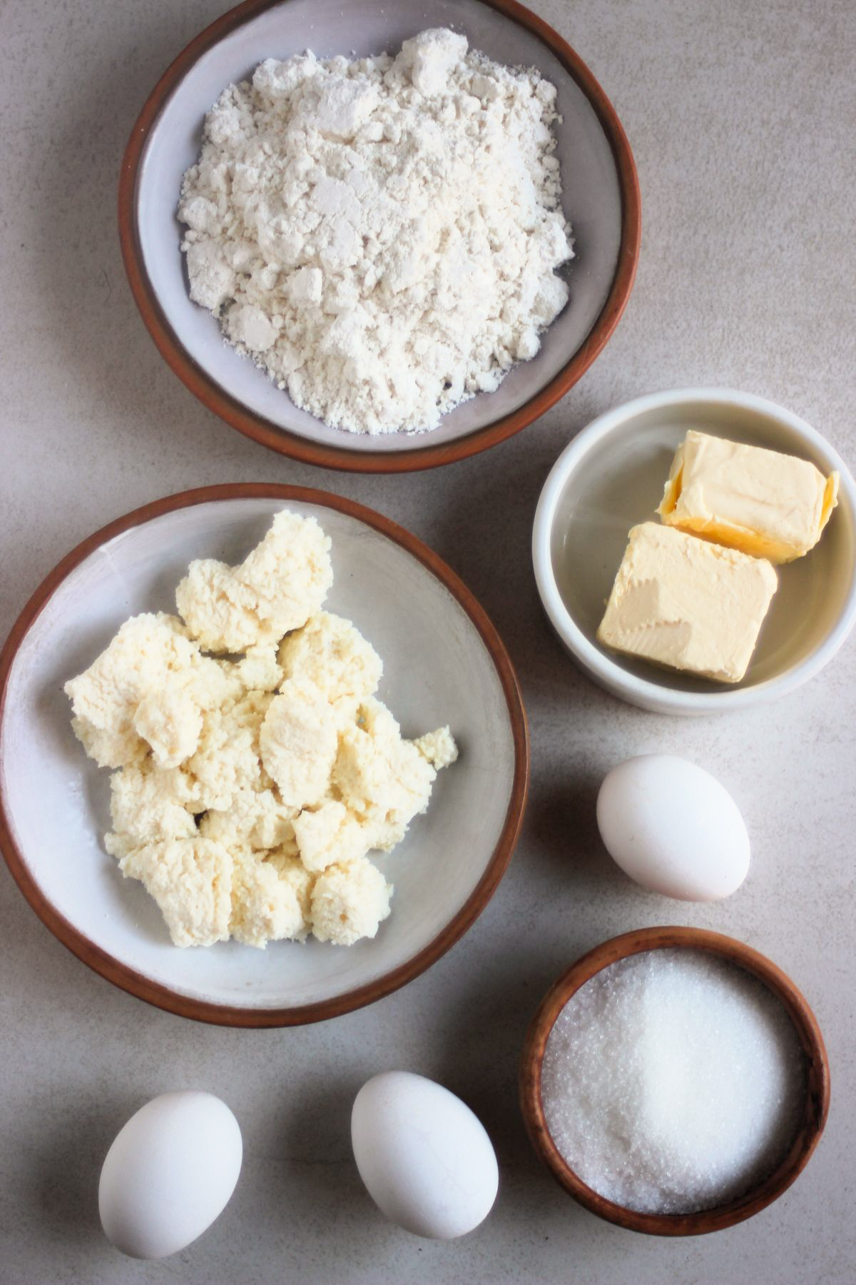 Top view of ricotta pie ingredients on a white surface.