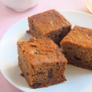 Three portions of date cake on a white plate.