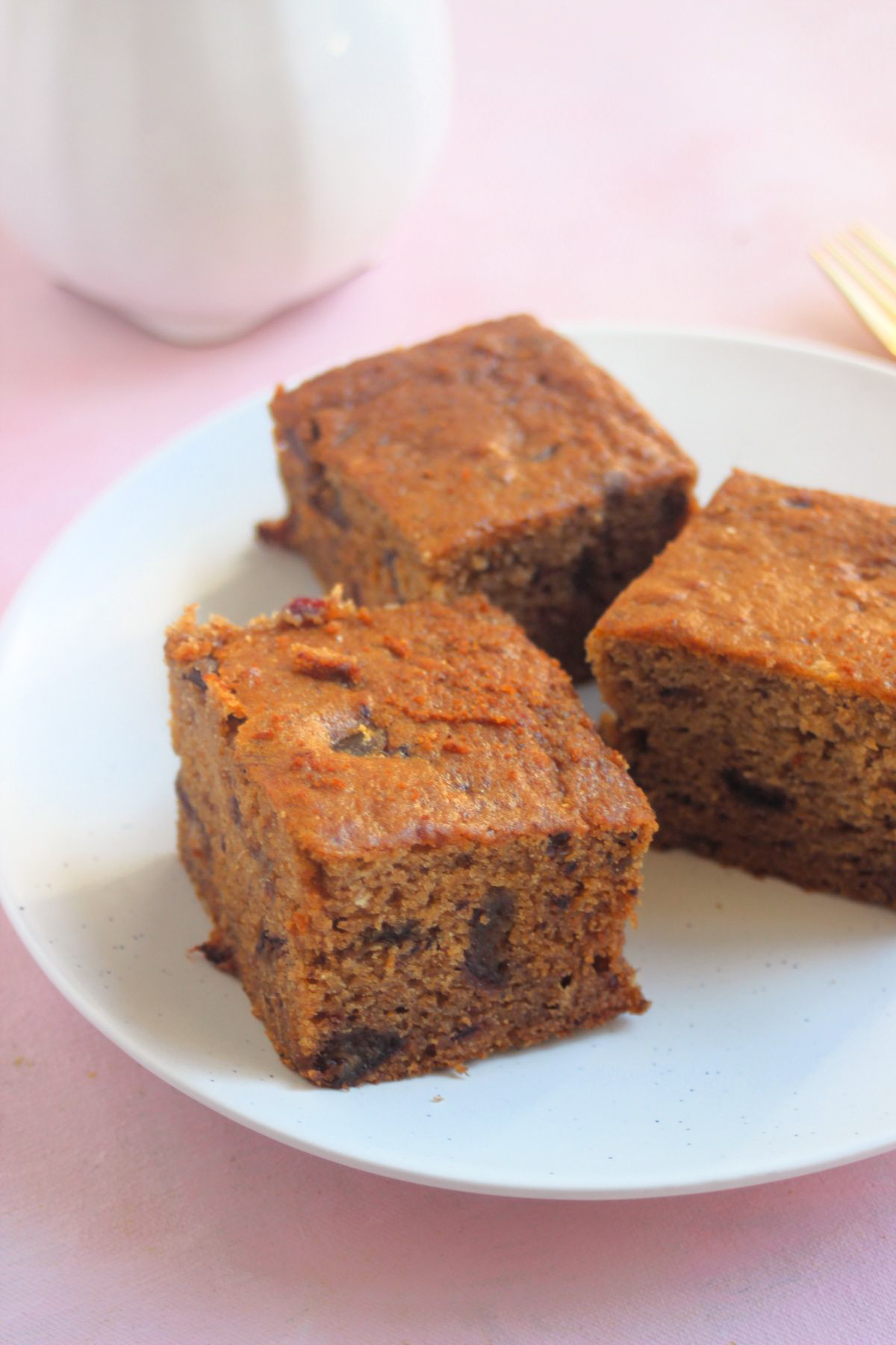 Three portions of date cake on a white plate.