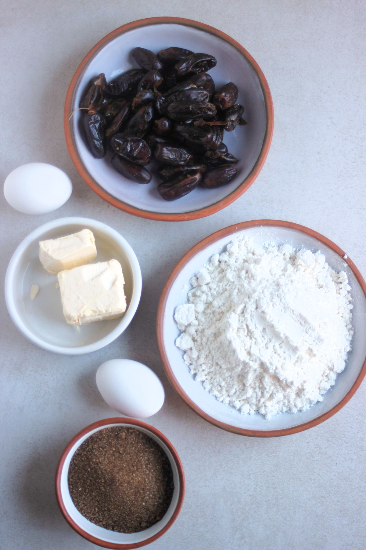 Top view of date cake ingredients on a white surface.