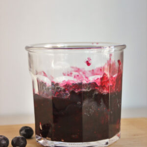 Jar with blueberry compote. Fresh blueberries on the side.