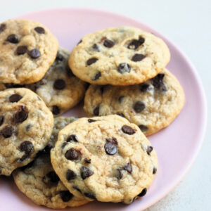 Chocolate chip cookies on a pink plate.