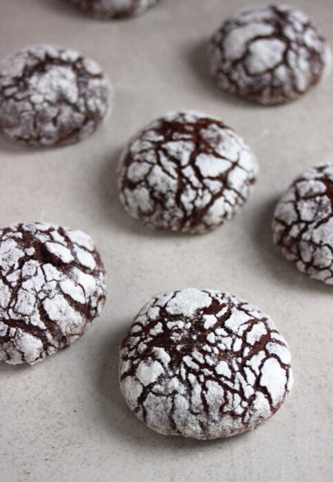 Chocolate crinkle cookies on a white surface.
