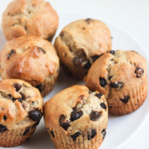 Banana chocolate chip muffins on a white plate.