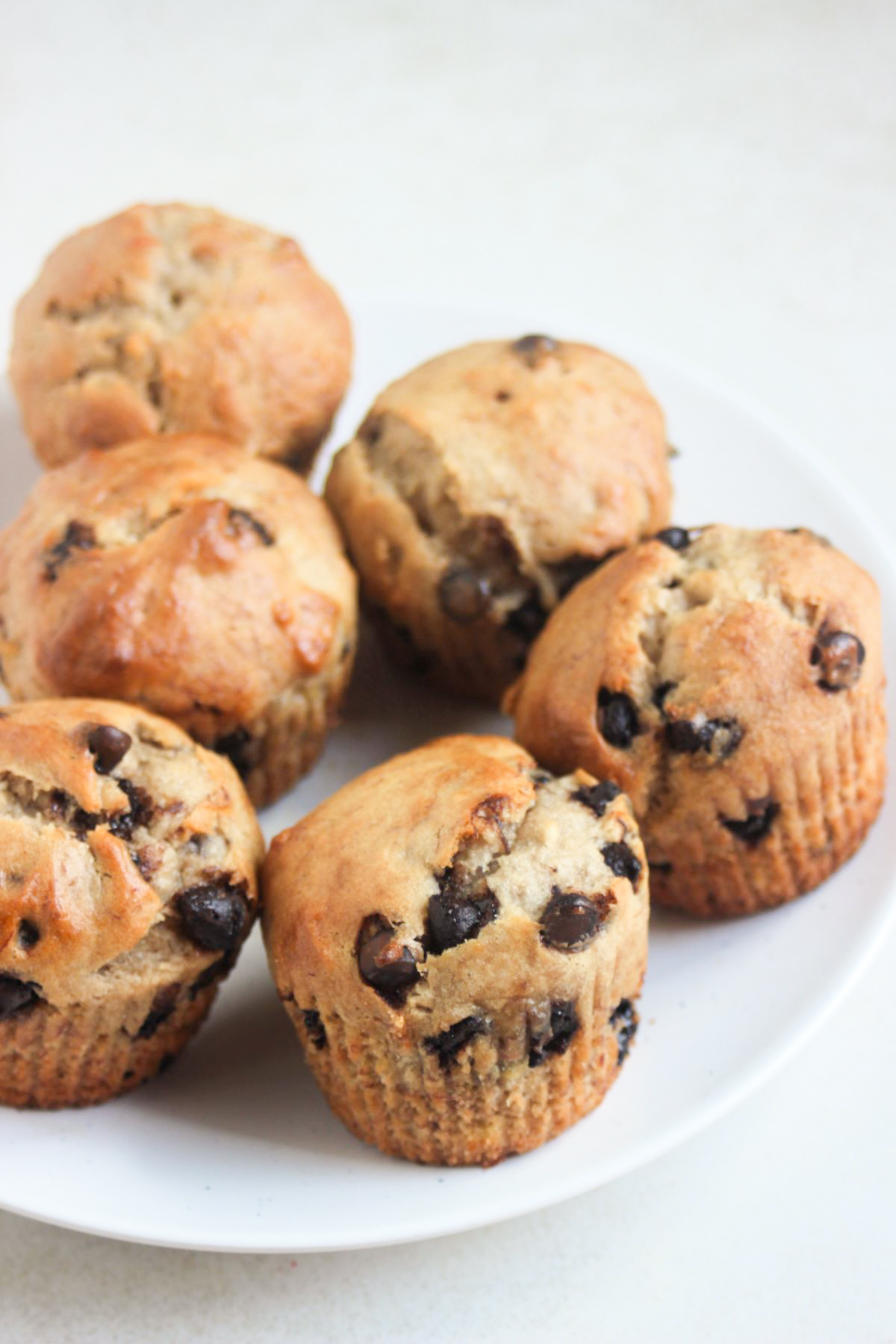 Banana chocolate chip muffins on a white plate.