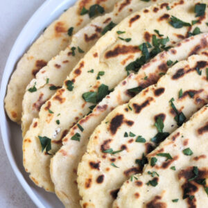 Flatbread plate with chopped fresh parsley on a white.