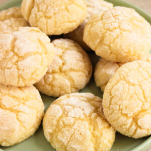 Lemon crinkle cookies on a light aqua plate.