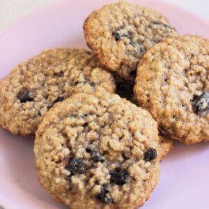 Oatmeal raisin cookies on a pink plate.