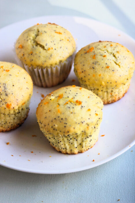Orange poppy seed muffins on a white plate.