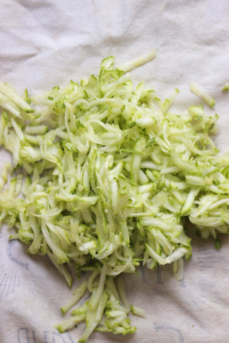 Top view of grated zucchinis on a white towel.