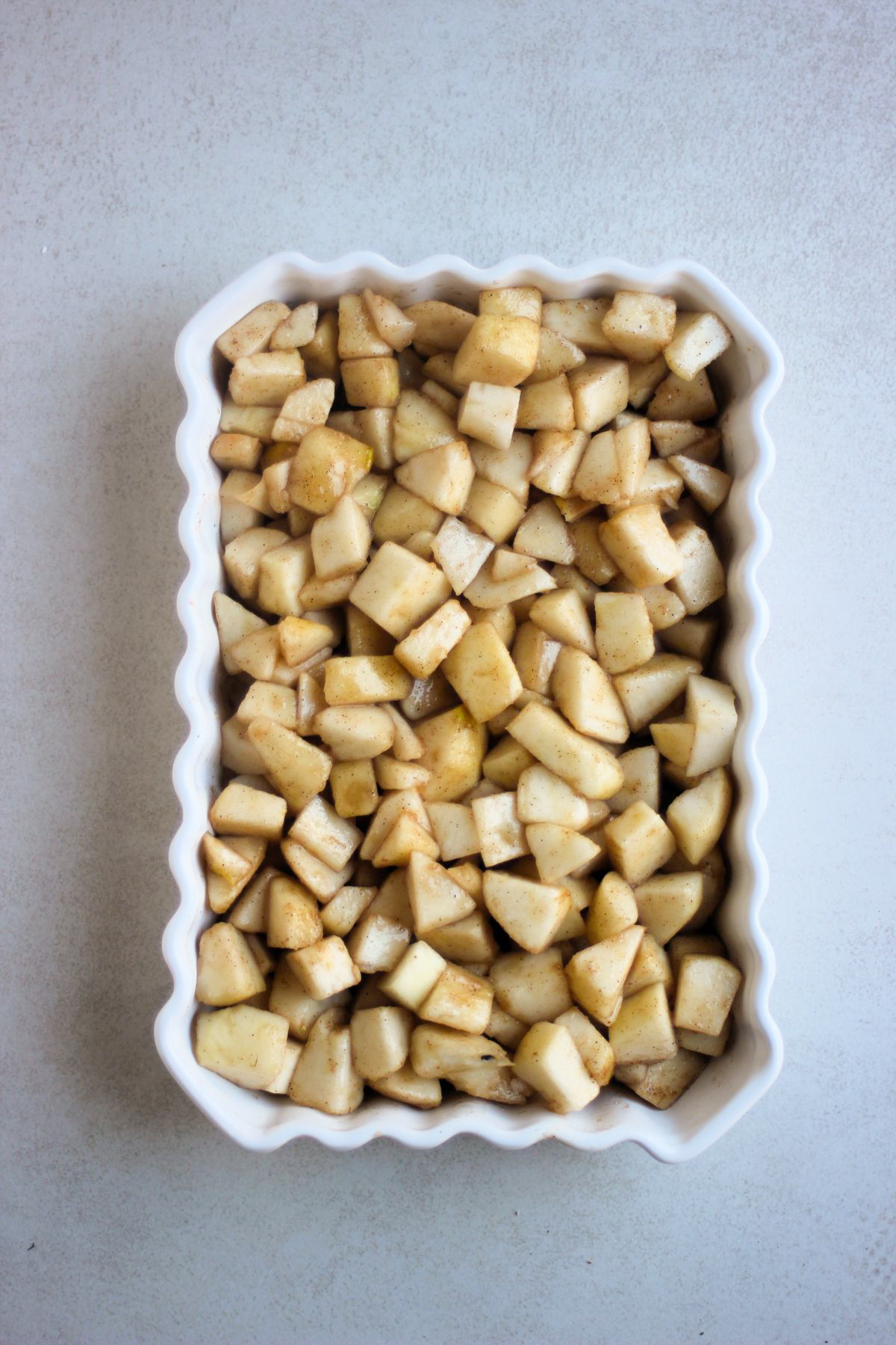 Rectangular baking dish with chopped pears seen from above.