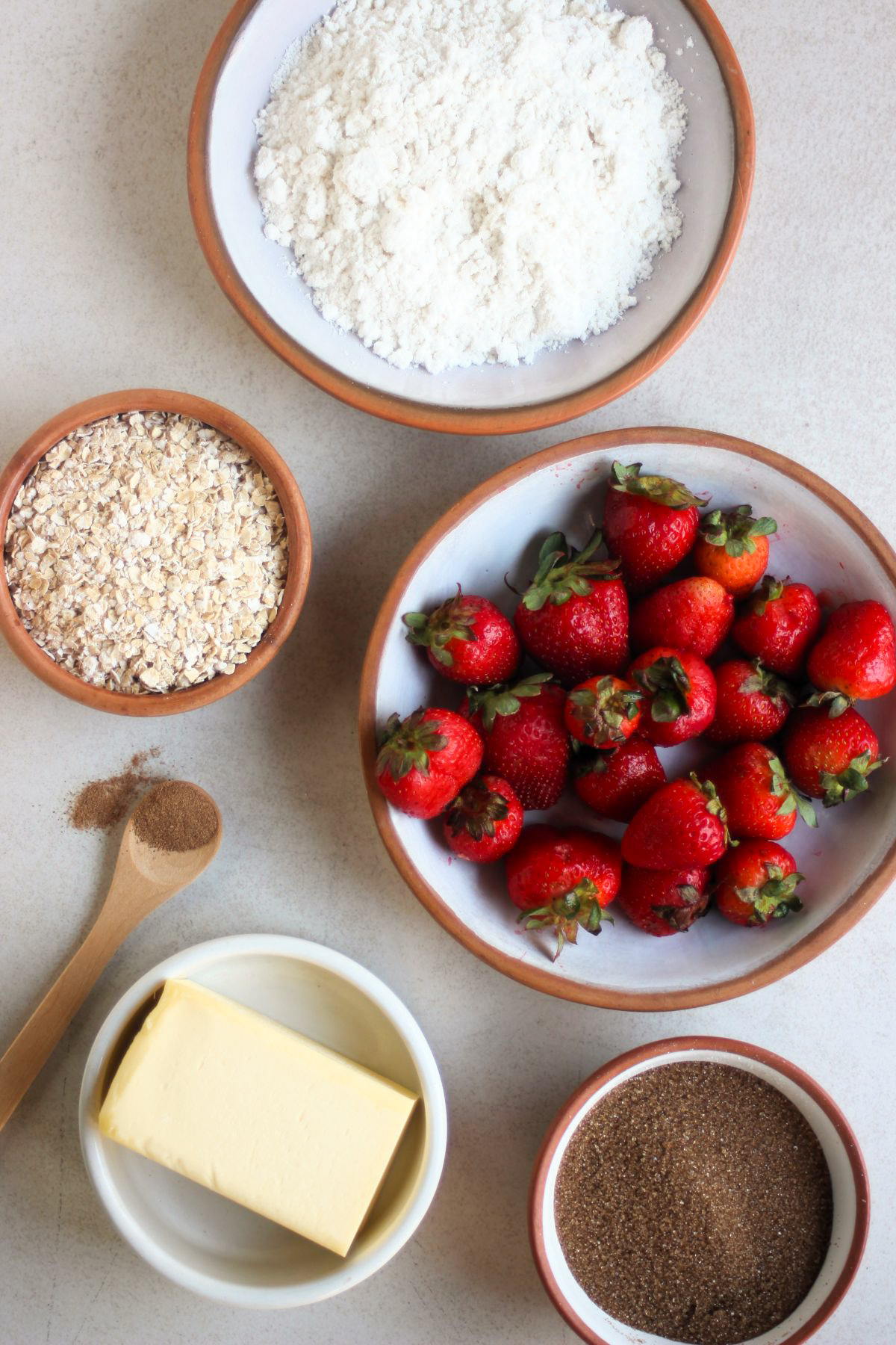 Top view of strawberry crisp bars ingredients on a white surface.