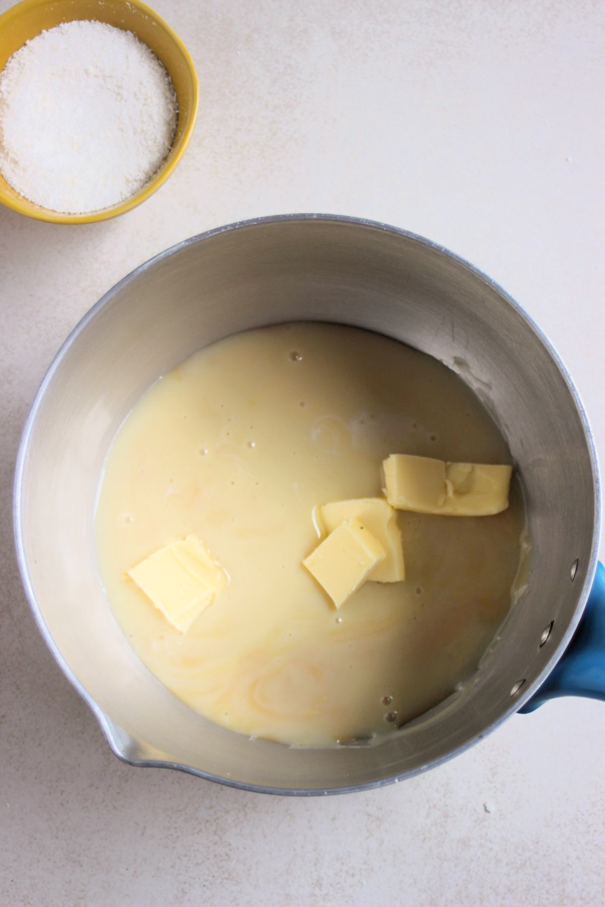 Deep pan with condensed milk and diced butter.